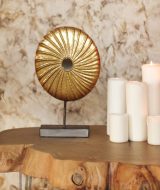 Set of white burning candles and stylish golden decoration placed on lumber table against marble wall